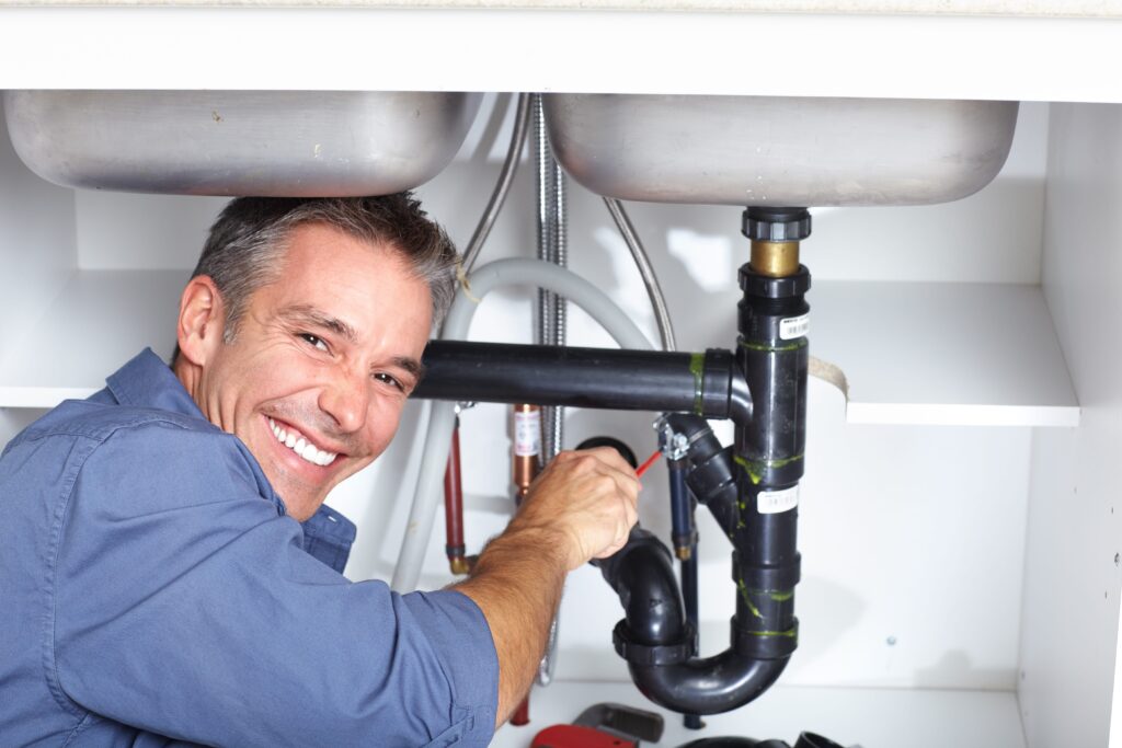 bigstock-Young-plumber-fixing-a-sink-at-19547801-min